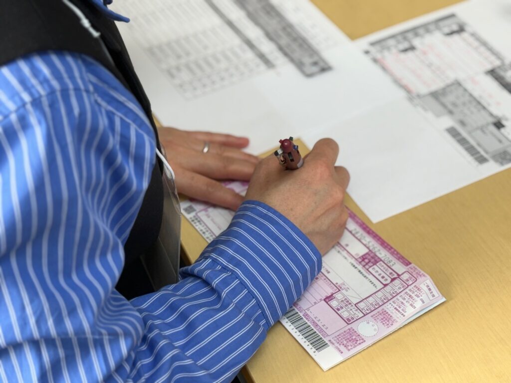 選挙為書きの発送のため、宛先ごとに伝票を手書きしている作業風景